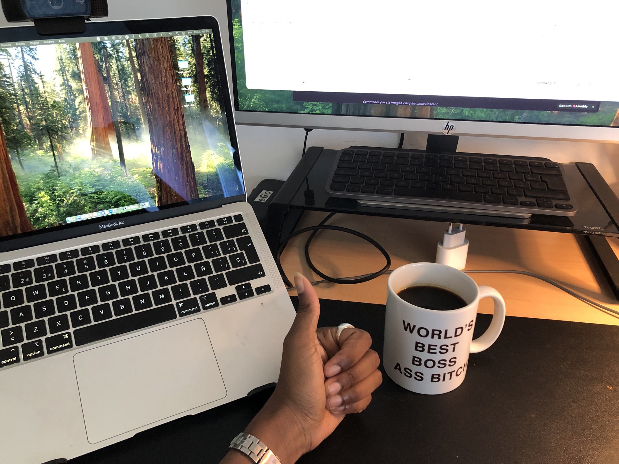 Espace de travail avec un MacBook, un écran externe et une tasse de café